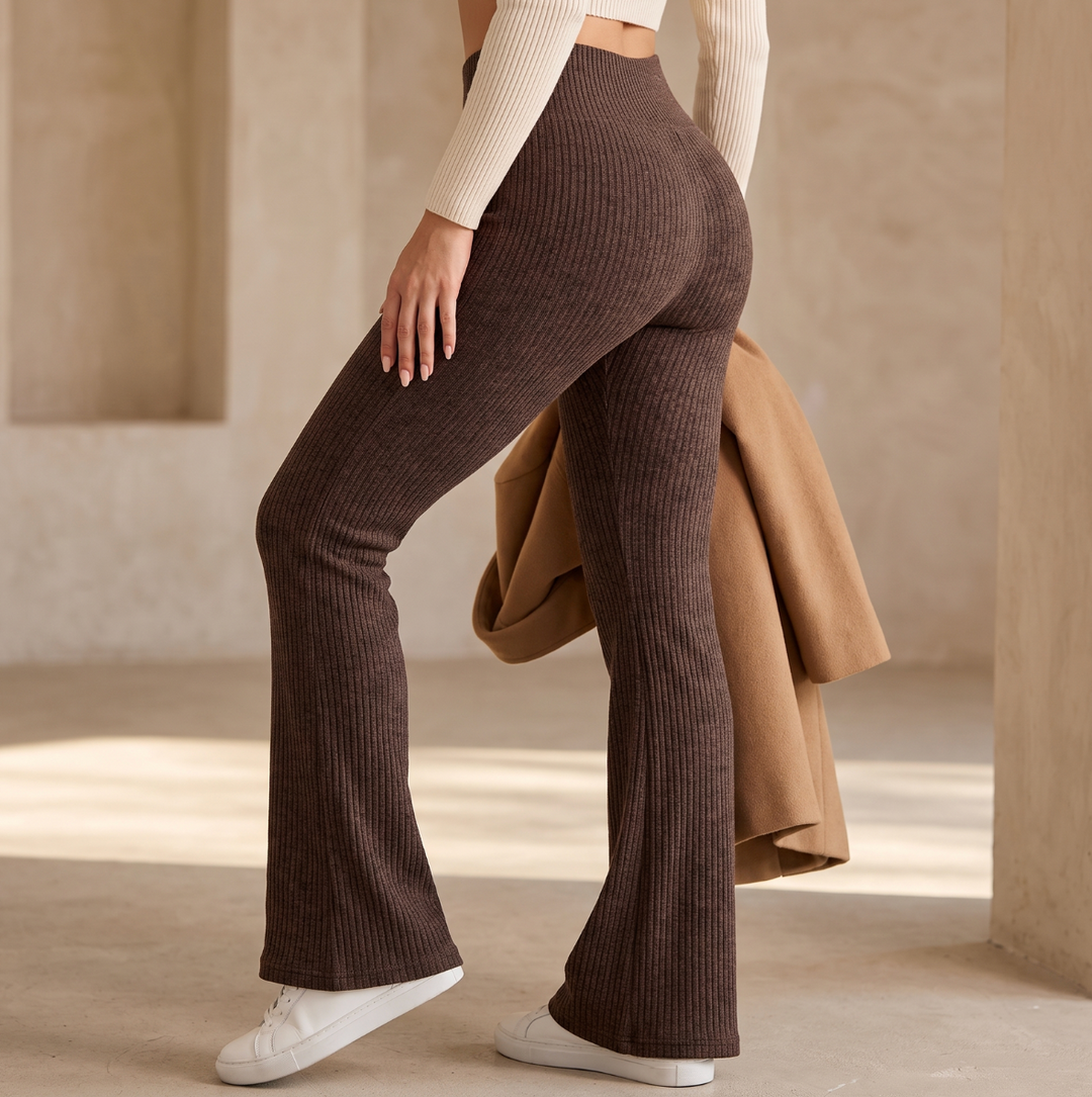Full-length brown flared leggings styled with sneakers and long coat